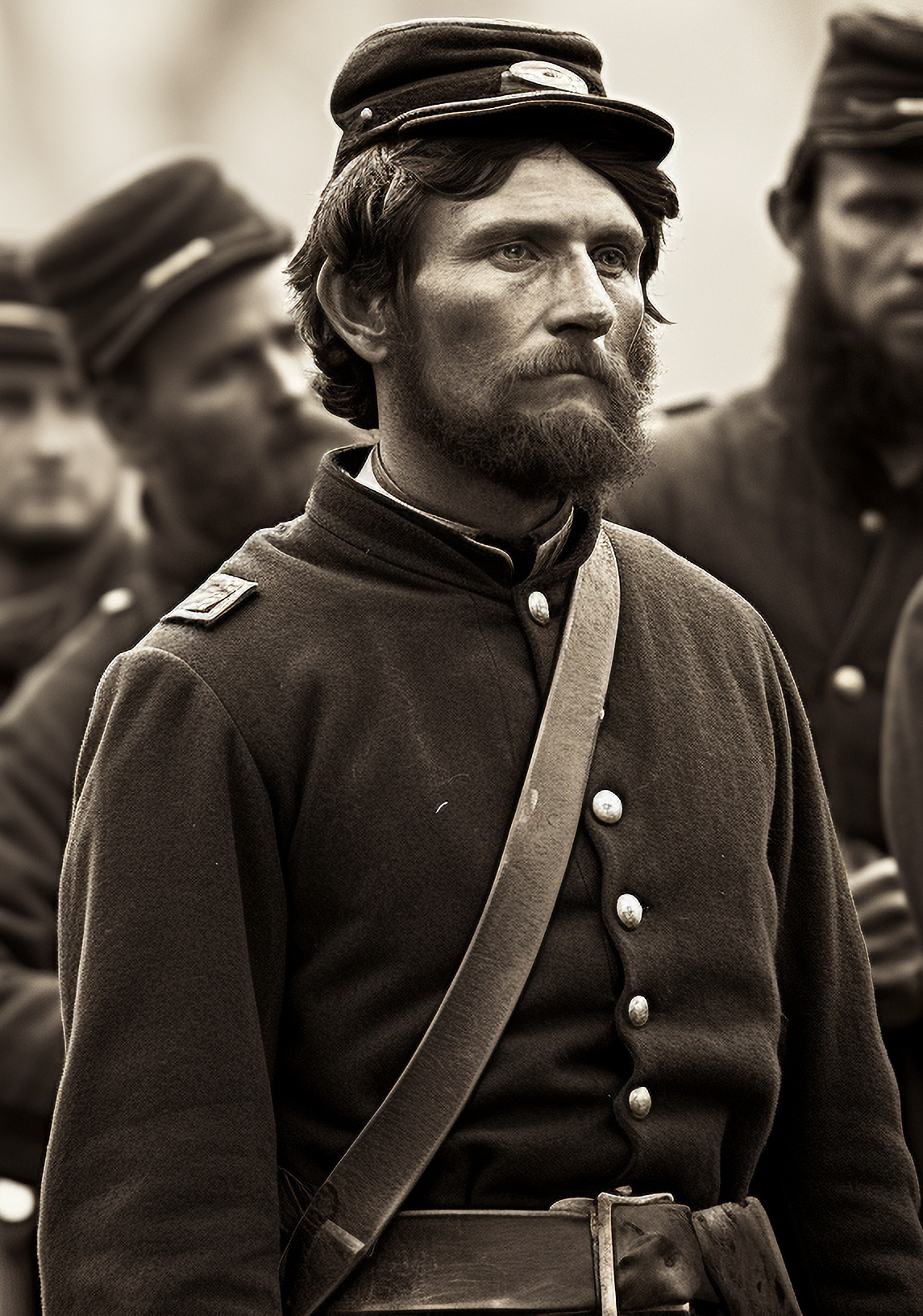 A group of soldiers carrying an american flag in a field
