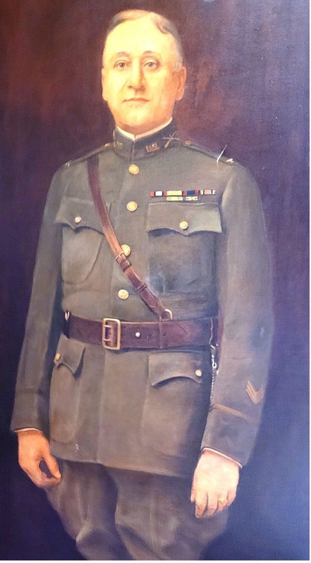 Portrait of a man in a military uniform, brown leather belt and shoulder strap.