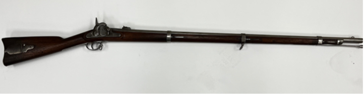 A long, brown rifle with metal accents lies horizontally against a white backdrop.