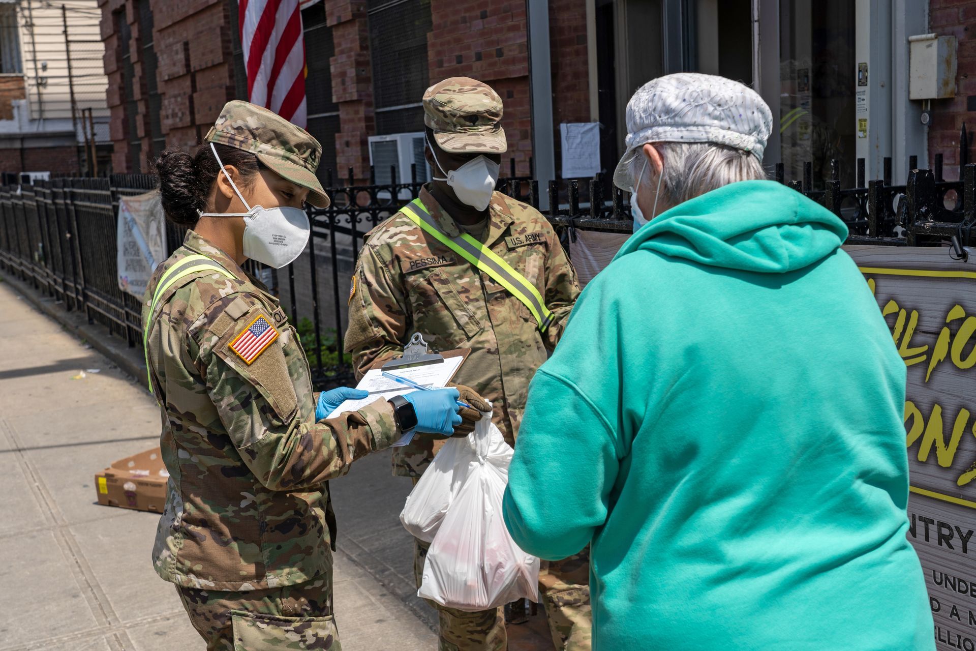 Soldiers in masks handing bags to a person outside, likely food assistance.