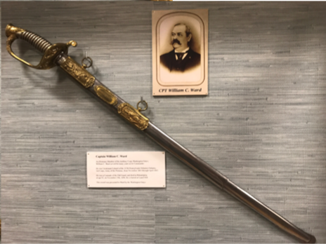 A sword with a gold handle and scabbard displayed with a portrait of Captain William C. Ward.