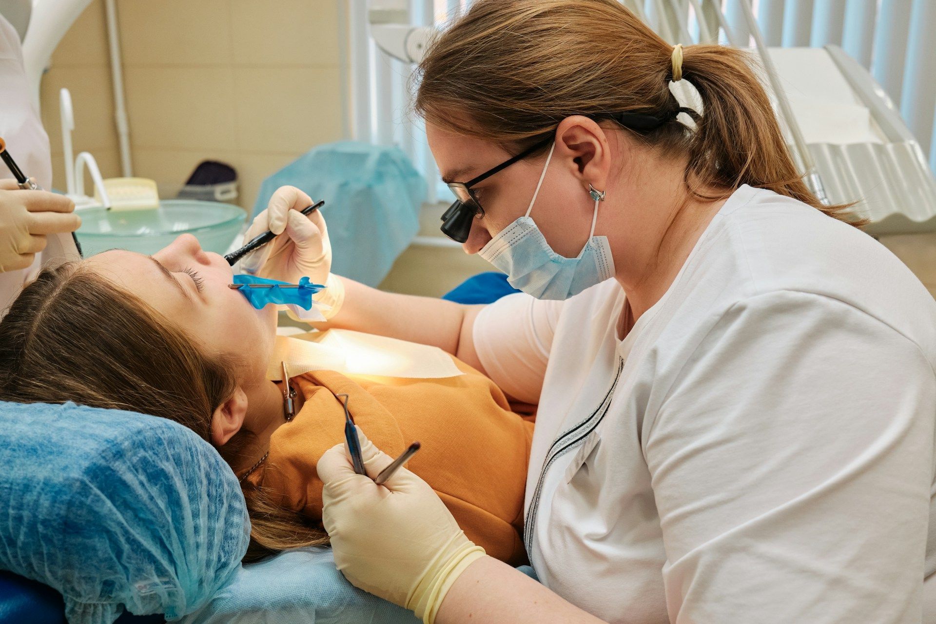A dentist is examining a patient's teeth in a dental office.