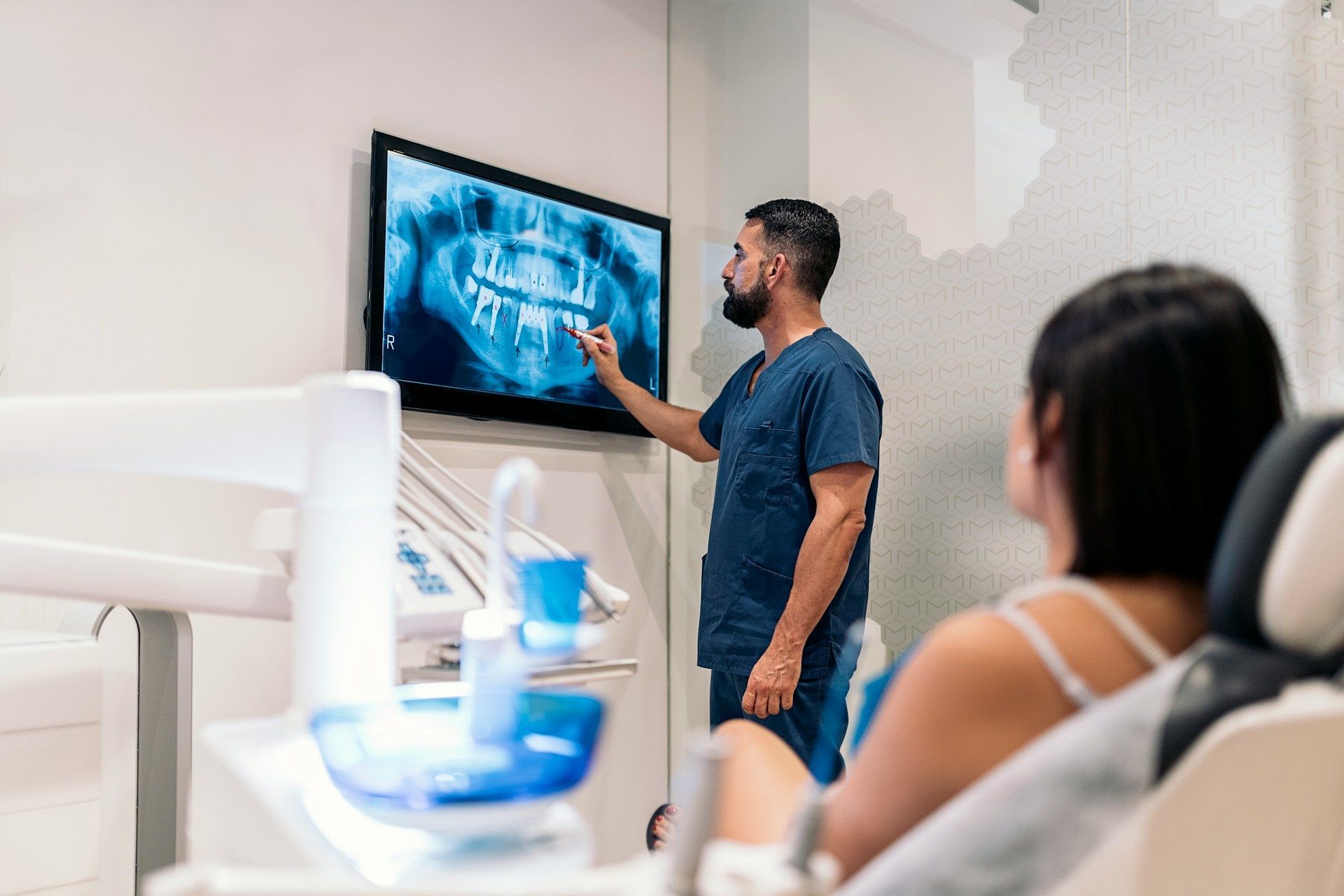 A dentist is explaining an x-ray to a patient in a dental office.