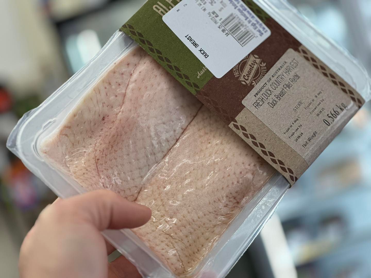 Hand Holding a Packaged Tray of Duck Breast Fillets with A Brown Label — West High Street Boutique Butchery In Coffs Harbour, NSW