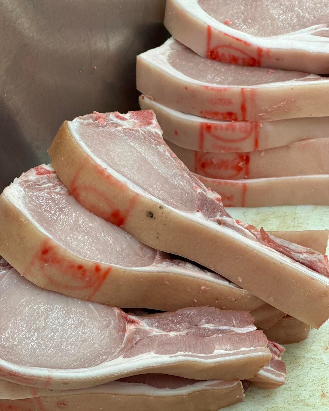 Raw Pork Chops, Stacked, with Visible Fat and Bone — West High Street Boutique Butchery In Coffs Harbour, NSW