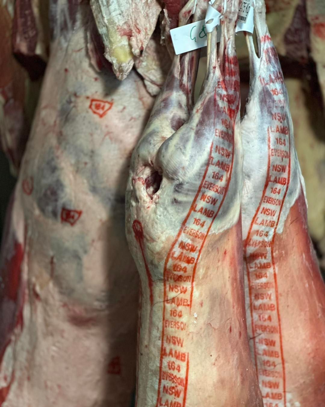 Close-Up of Two Raw Lamb Carcasses Hanging — West High Street Boutique Butchery In Coffs Harbour, NSW