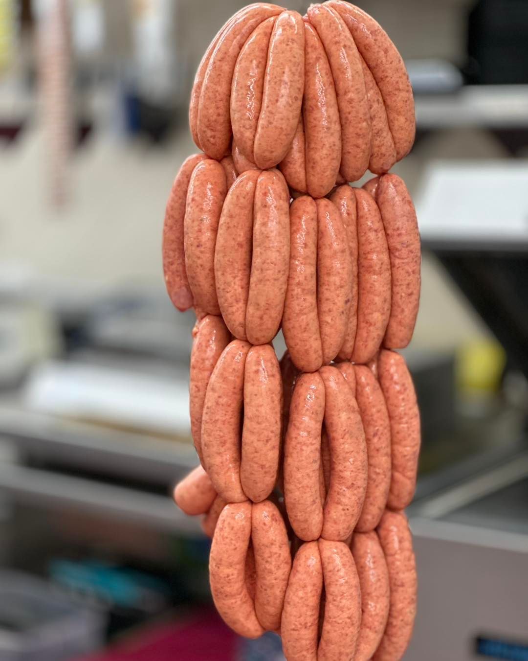 Sausage Links Hanging Vertically, Light Pink in Color — West High Street Boutique Butchery In Coffs Harbour, NSW
