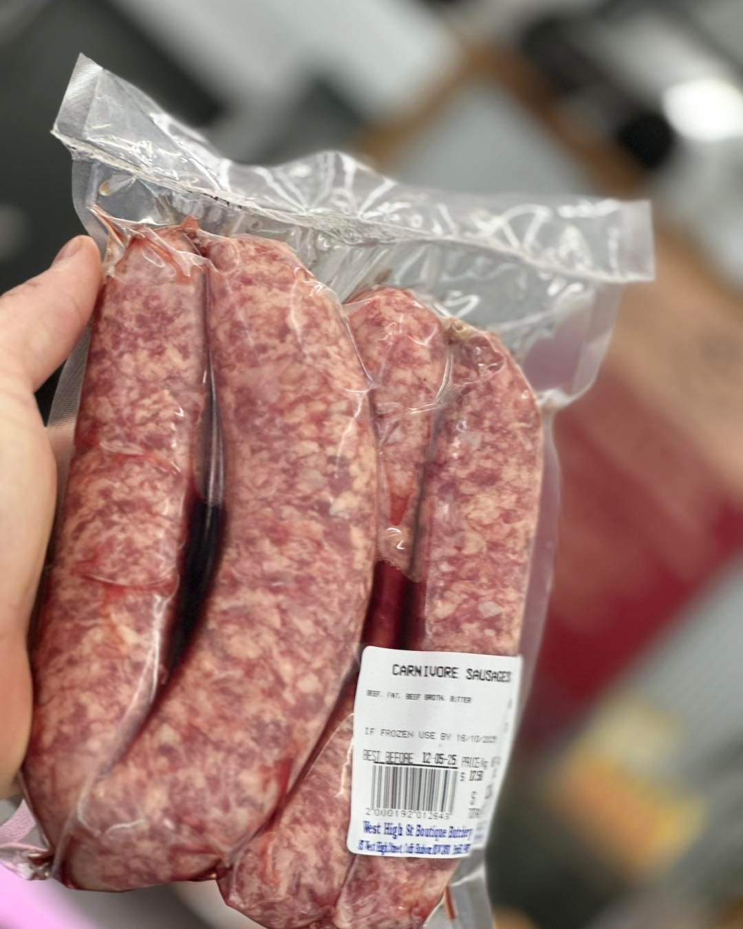 Hand Holding a Package of Raw Sausages in A Clear Plastic Wrap — West High Street Boutique Butchery In Coffs Harbour, NSW