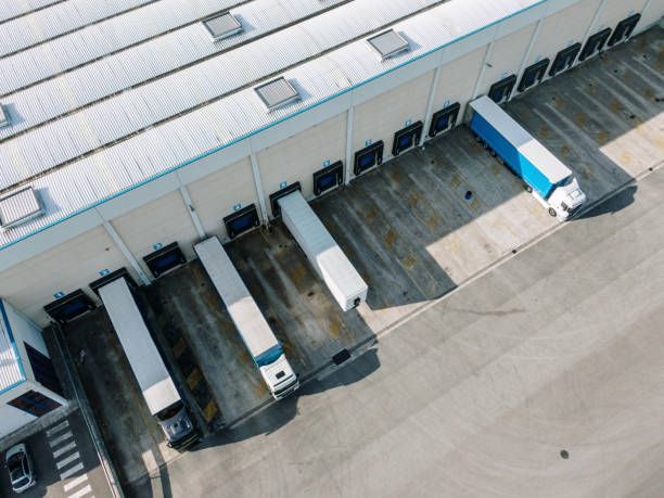 An aerial view of a warehouse with trucks parked in front of it.