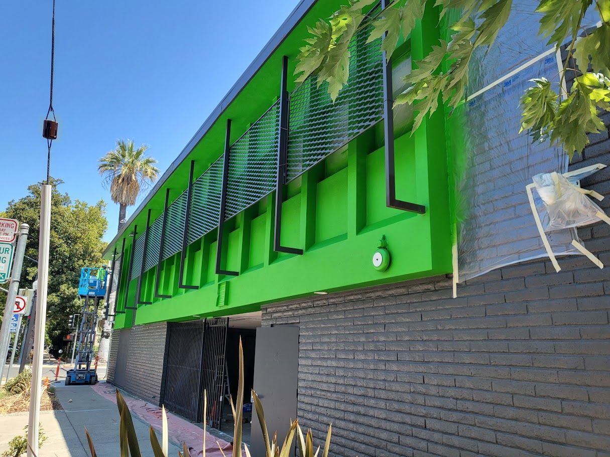 Green and black building exterior with lattice design.