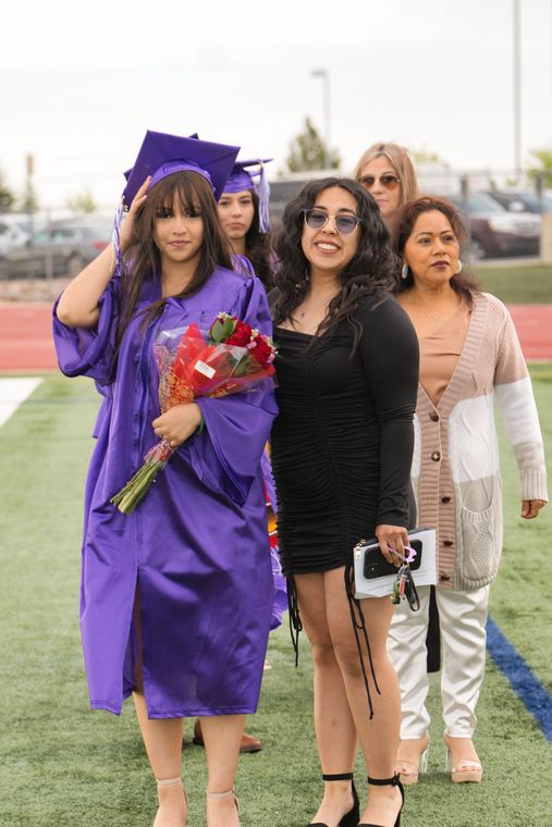 A group of women are walking on a field at a graduation ceremony.