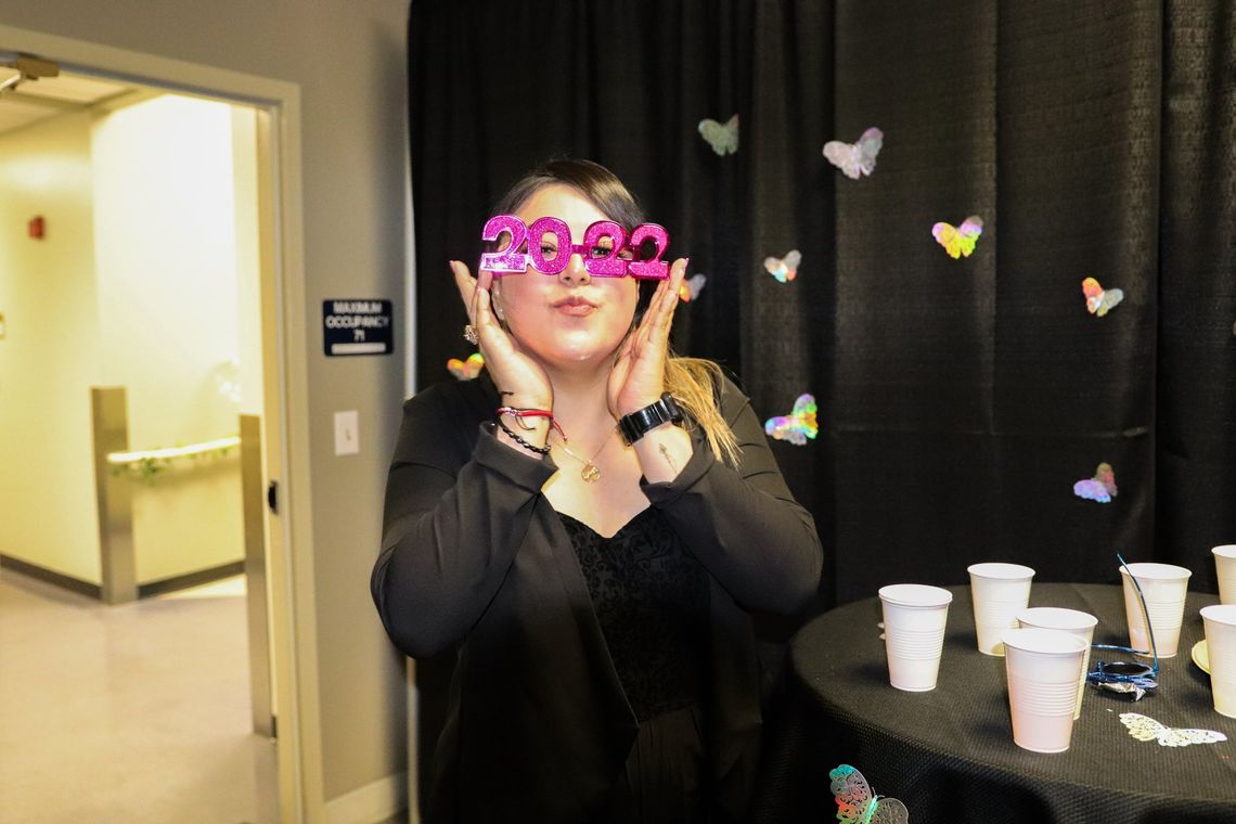 A woman wearing a pair of pink glasses with the year 2020 on them.