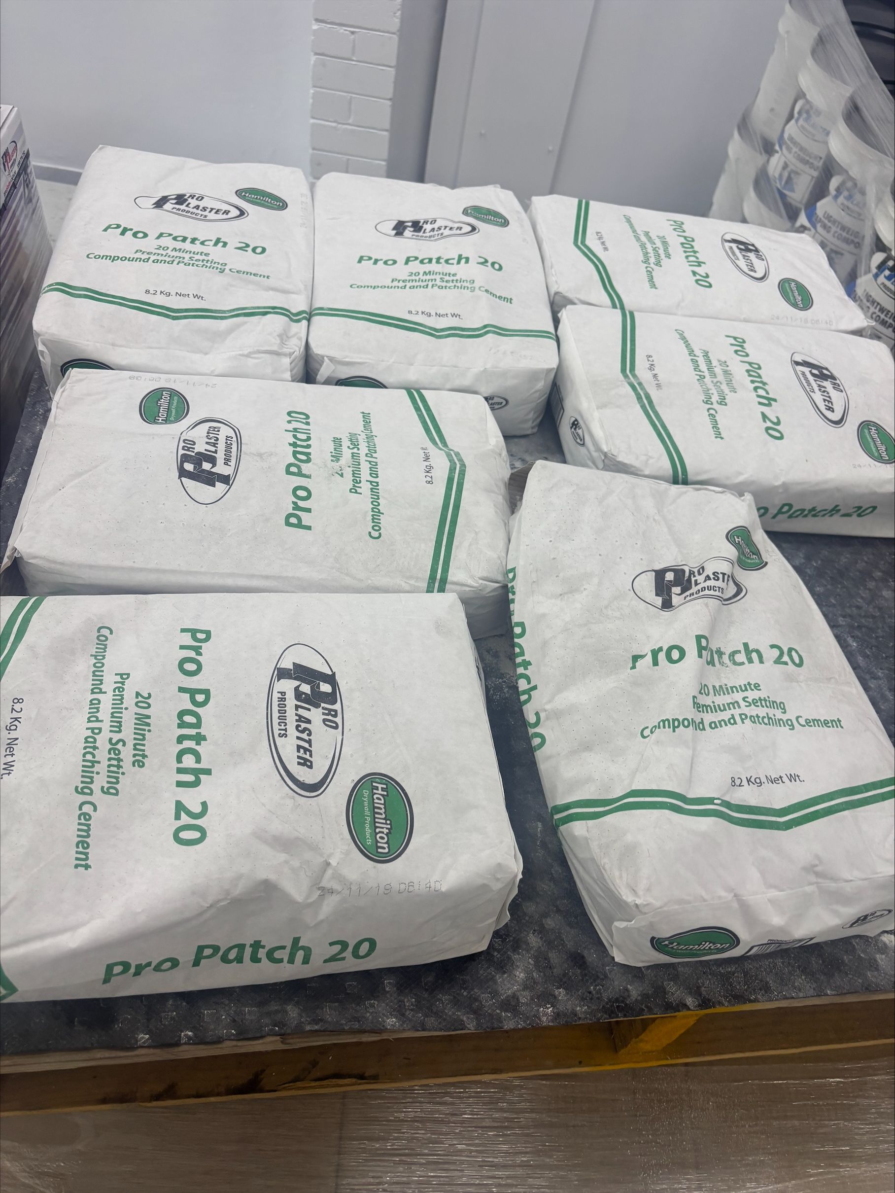 A Man in White Helmet is Applying Tape to a White Wall— North Coast Plaster Solutions in Lismore, NSW