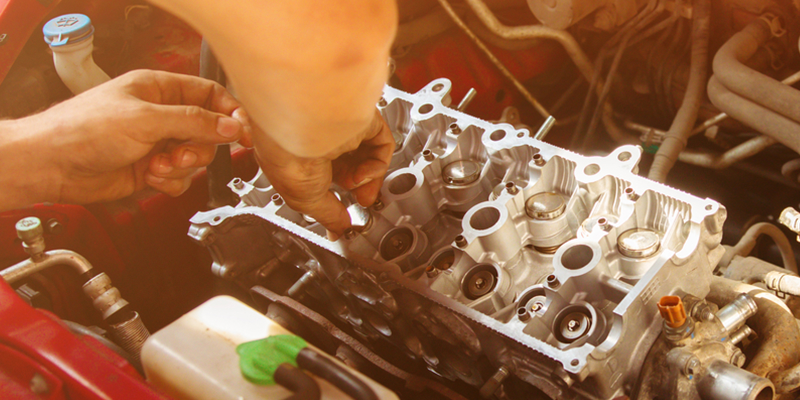 A man is working on the engine of a car.
