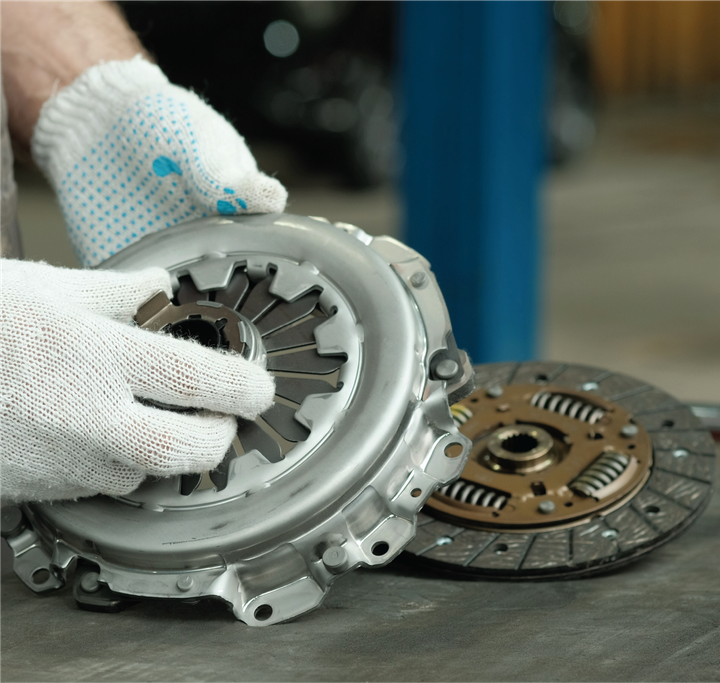 A person wearing white gloves is working on a clutch