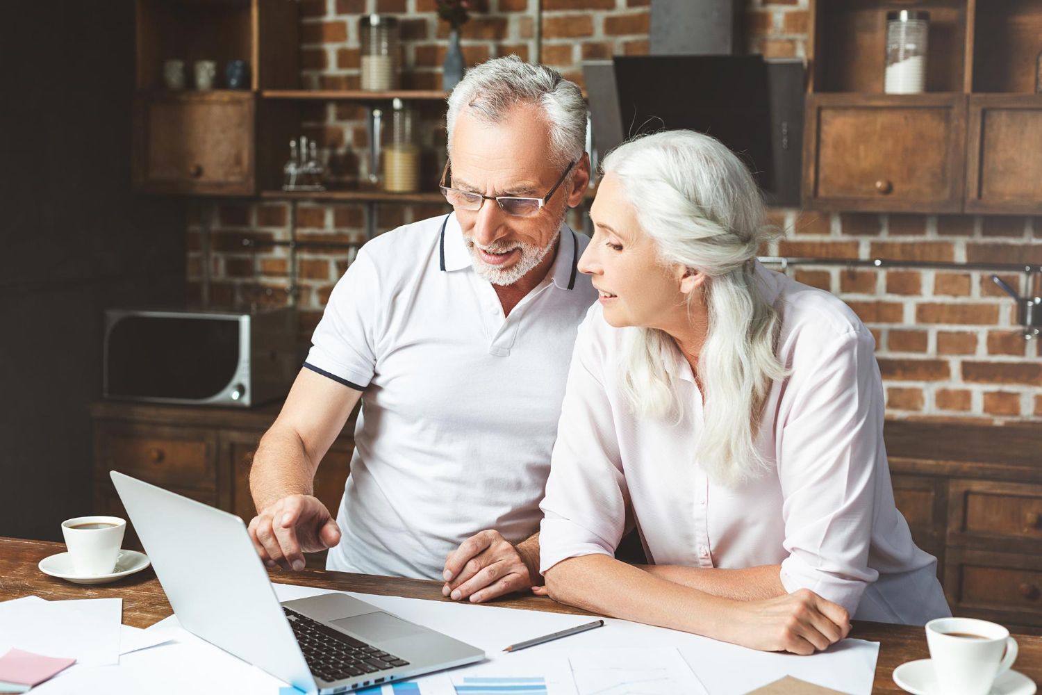 A man with a backpack is standing next to a lake in the woods.
