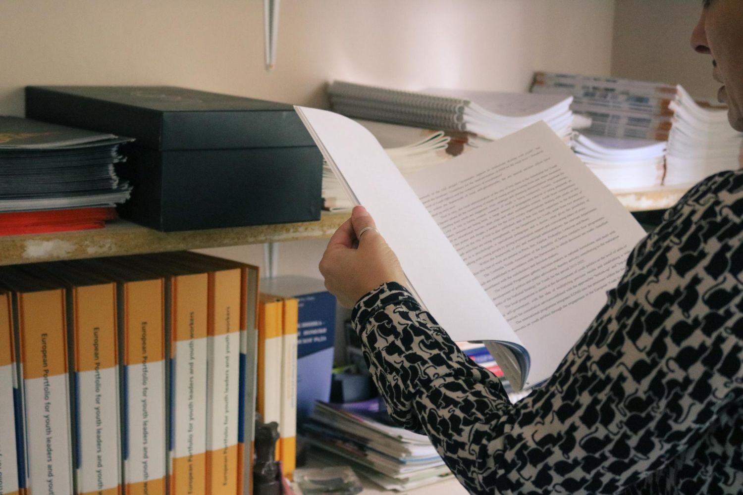A man with a backpack is standing next to a lake in the woods.