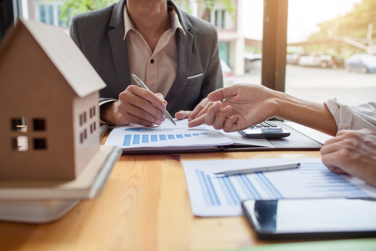 A man with a backpack is standing next to a lake in the woods.