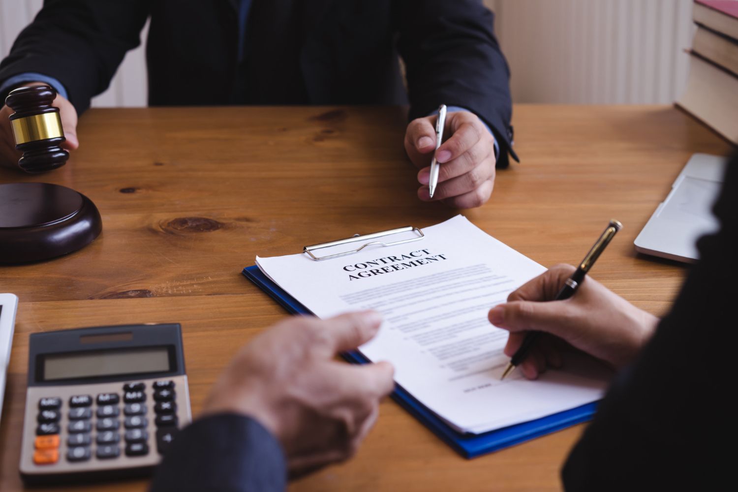 A man with a backpack is standing next to a lake in the woods.