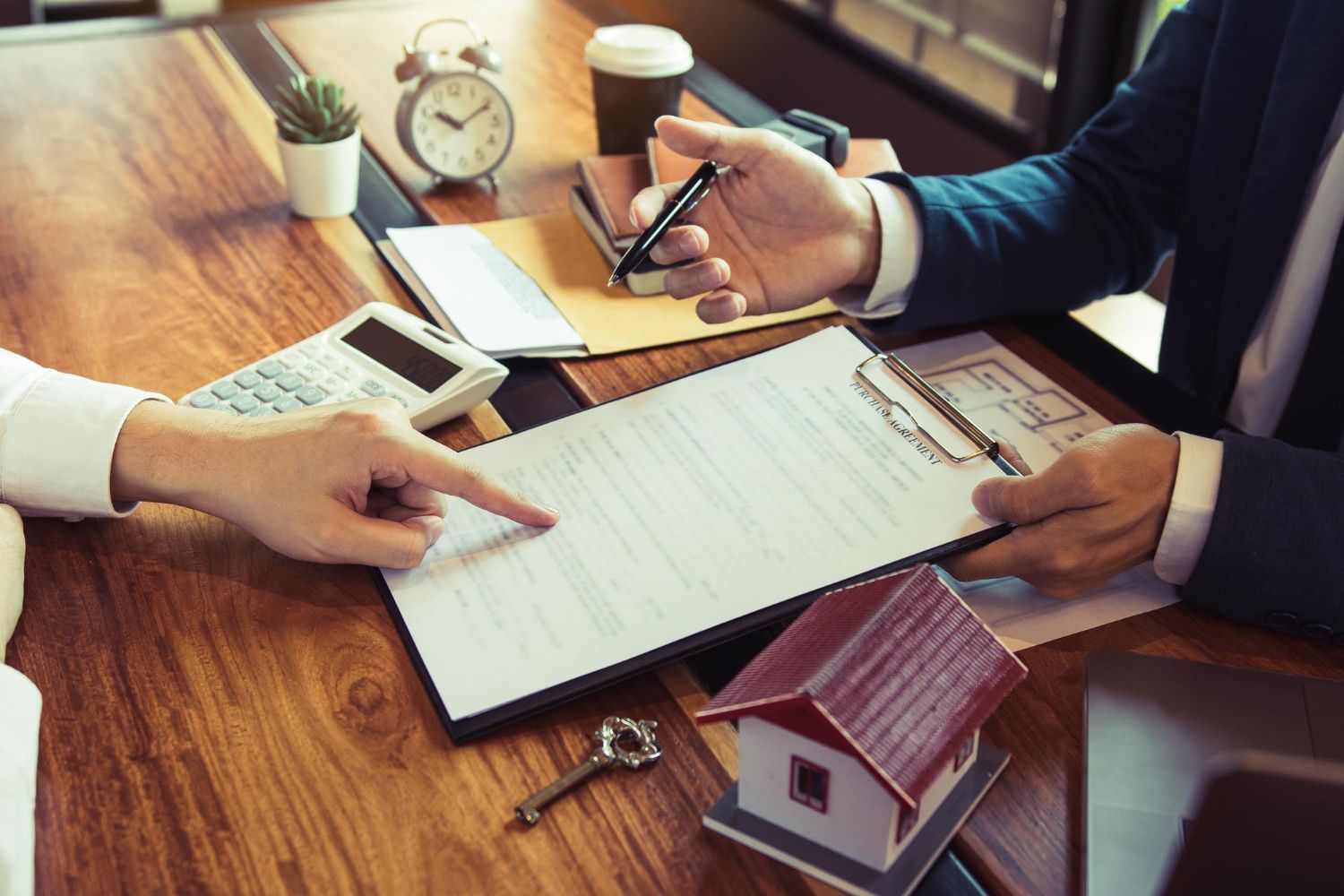 A man with a backpack is standing next to a lake in the woods.