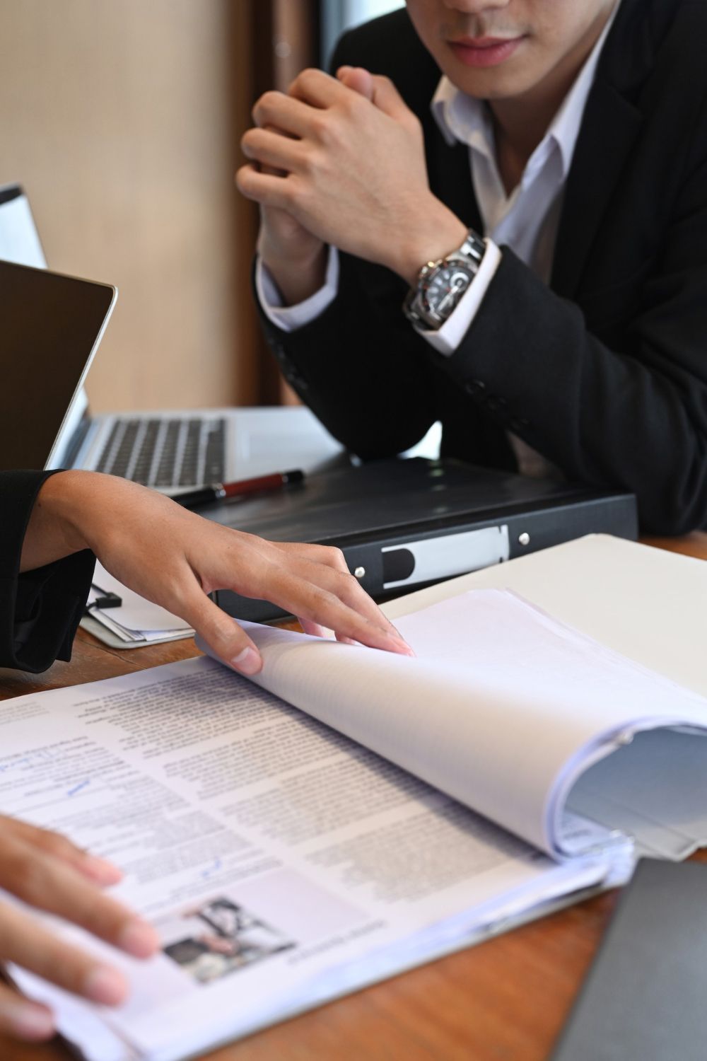 A man with a backpack is standing next to a lake in the woods.