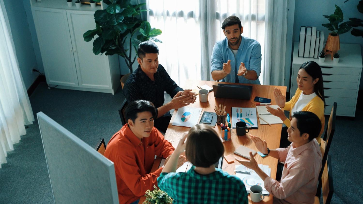 A man with a backpack is standing next to a lake in the woods.
