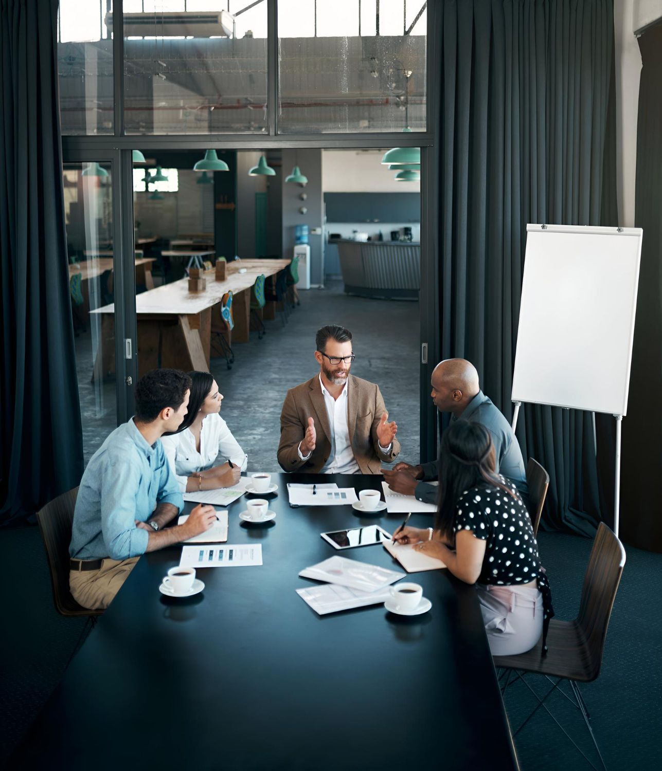 A man with a backpack is standing next to a lake in the woods.