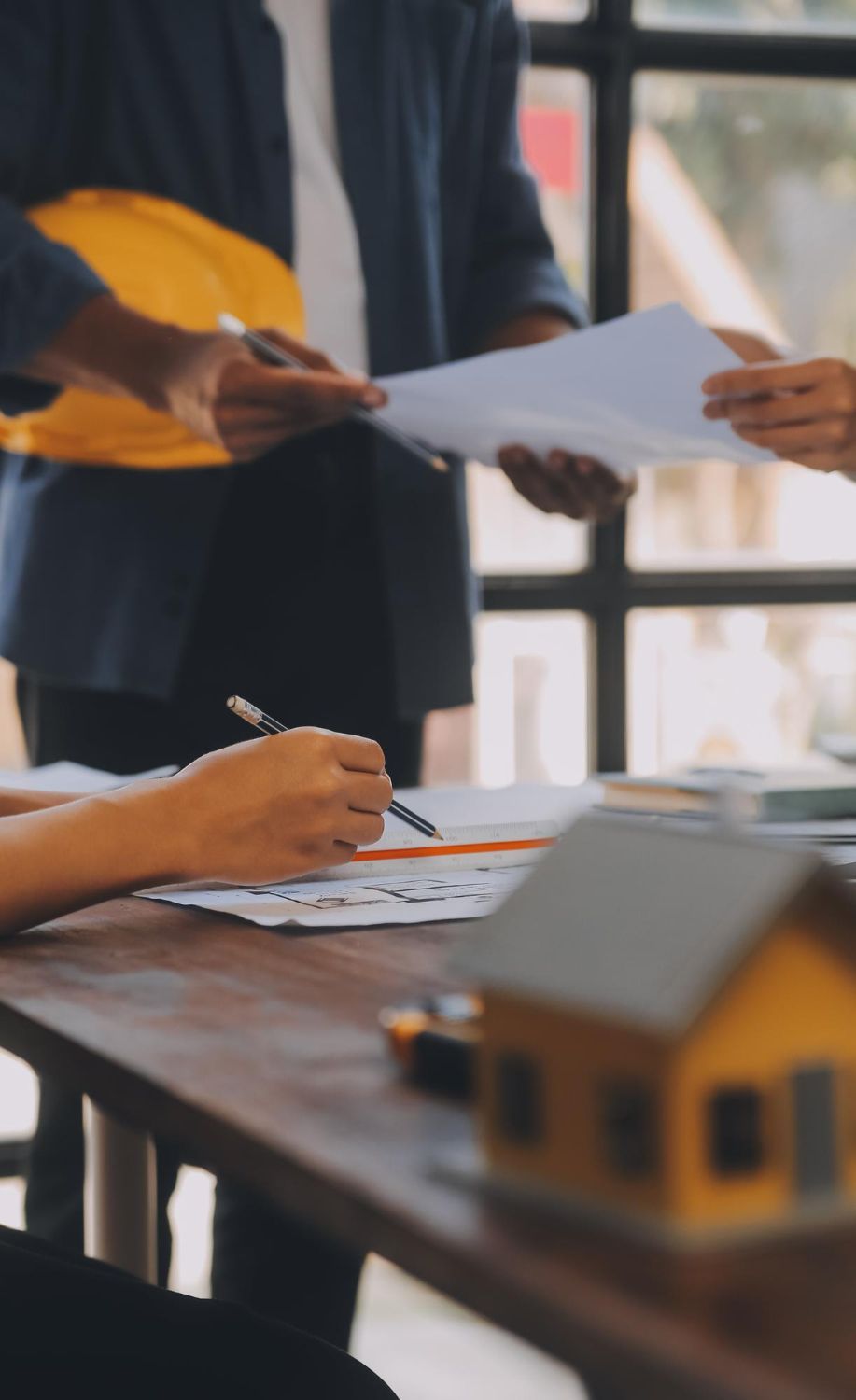 A man with a backpack is standing next to a lake in the woods.