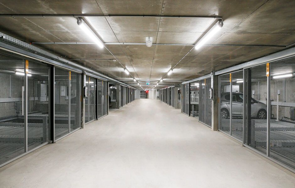 Et langt tomt parkeringshus med biler parkeret deri.