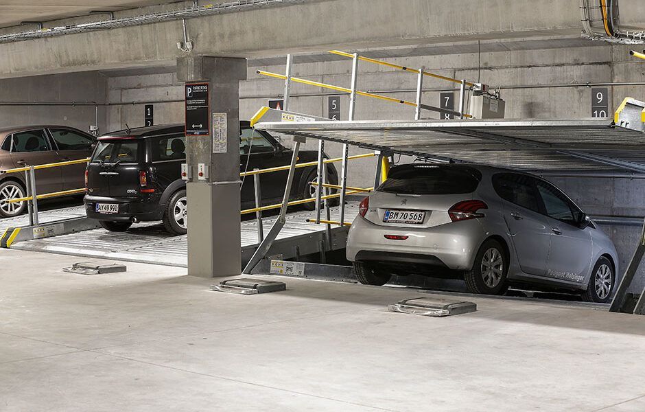 En række biler er parkeret i en parkeringskælder.