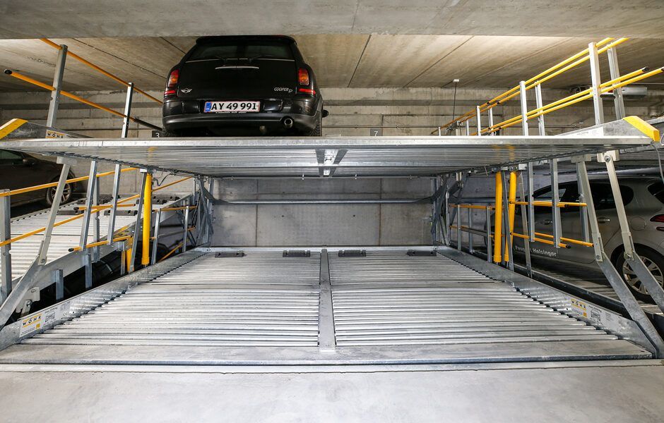 En bil er parkeret oven på en anden bil i en parkeringskælder.