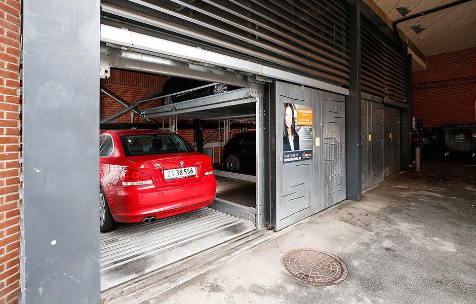 En rød bil er parkeret i et parkeringshus.