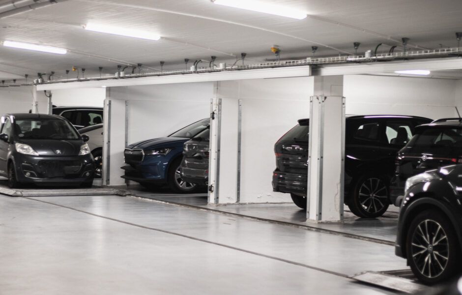 En række biler er parkeret i en parkeringskælder.