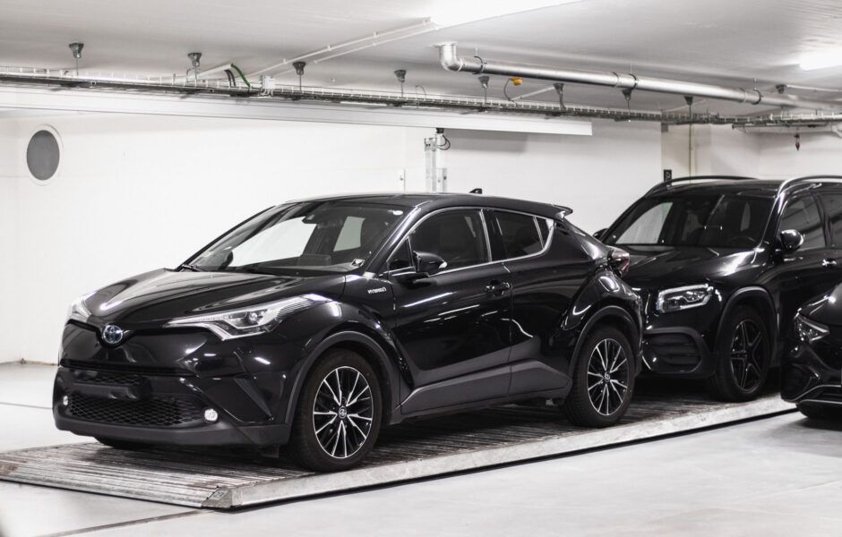 To sorte biler er parkeret ved siden af ​​hinanden i en parkeringskælder.