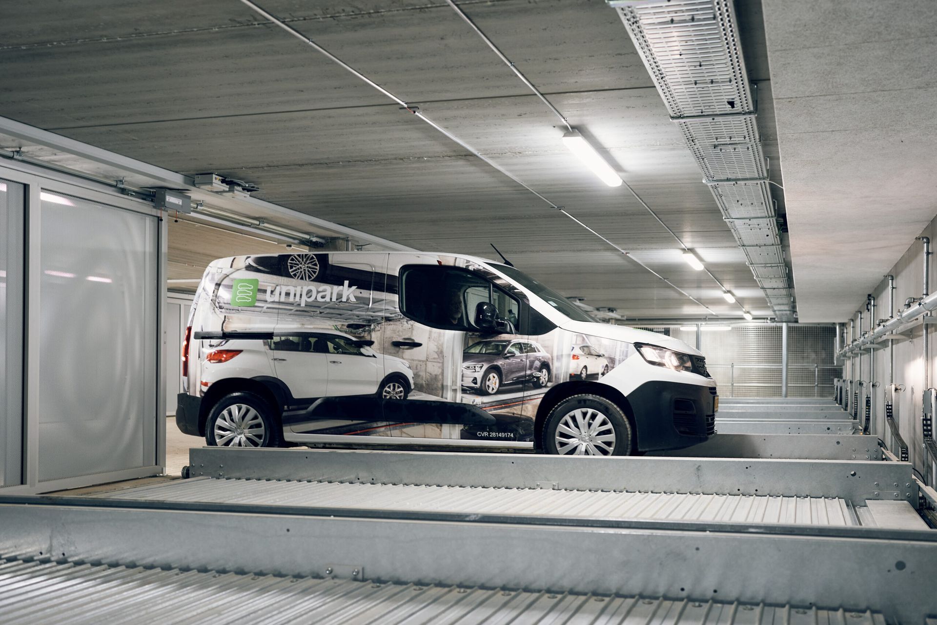 En hvid varevogn er parkeret i en parkeringskælder.