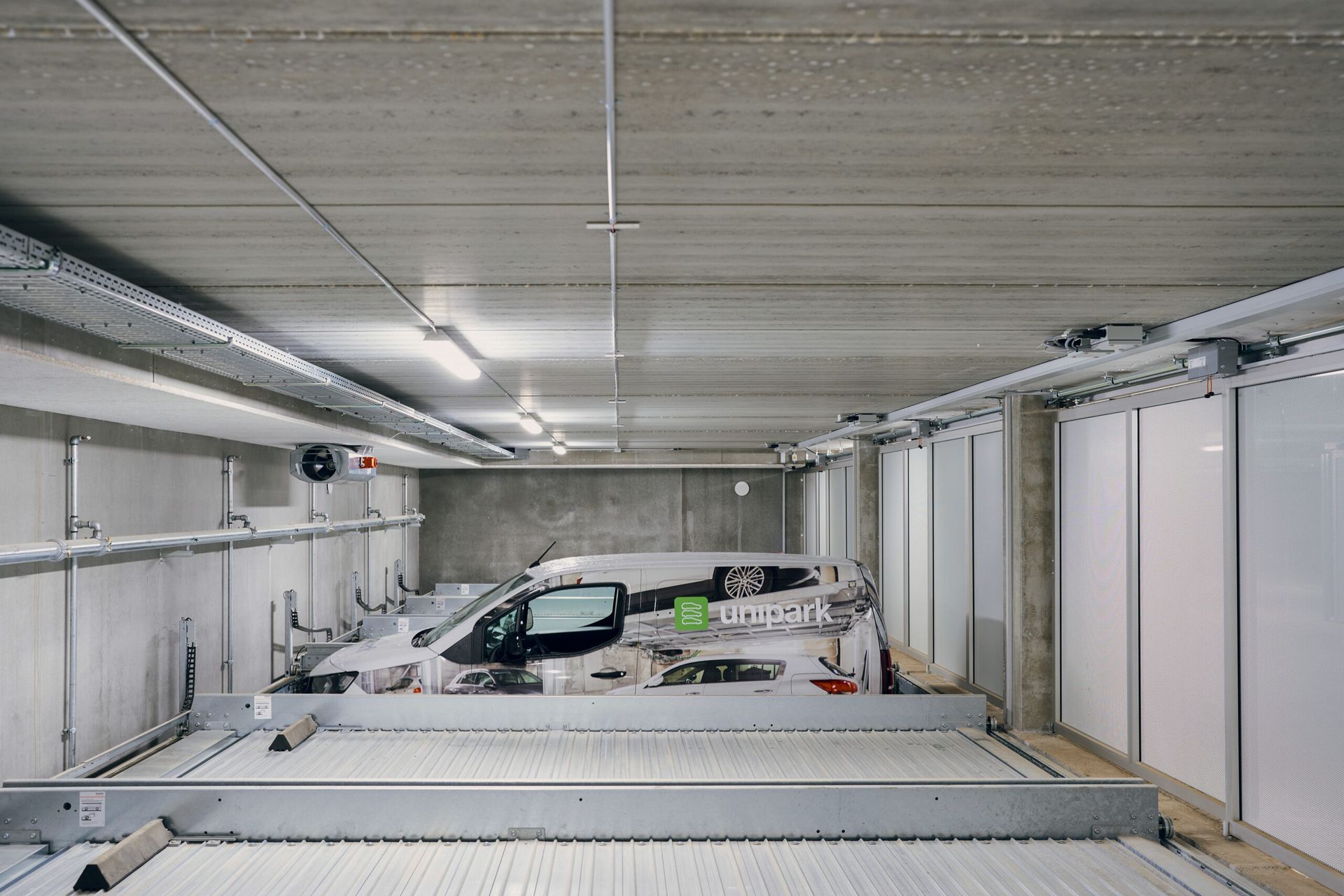 En hvid varevogn er parkeret i en parkeringskælder.