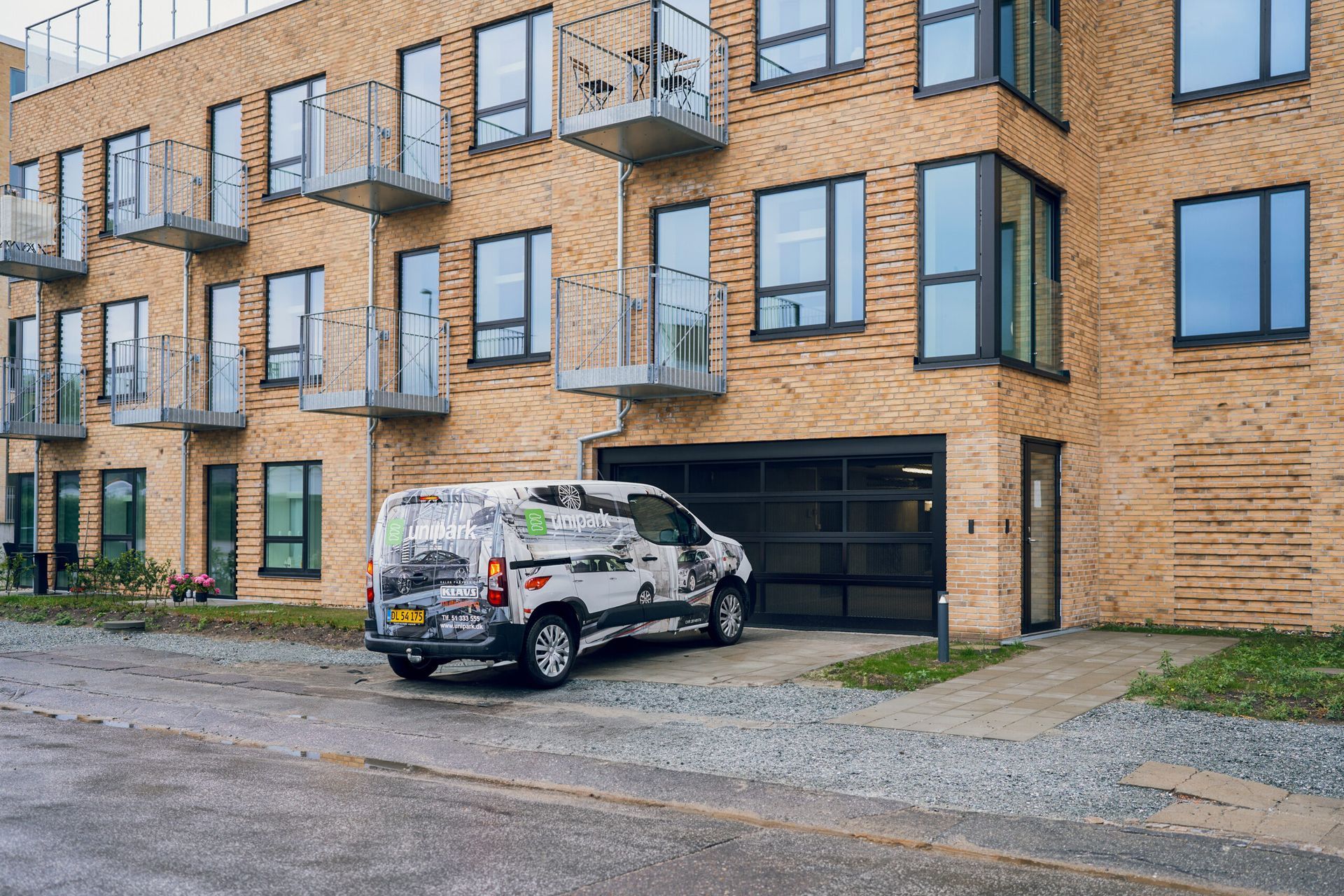 En varevogn er parkeret foran en murstensbygning.