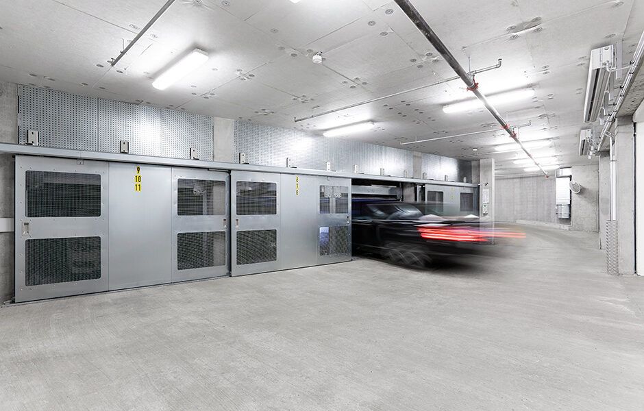 En bil kører gennem en skydedør i en parkeringskælder.