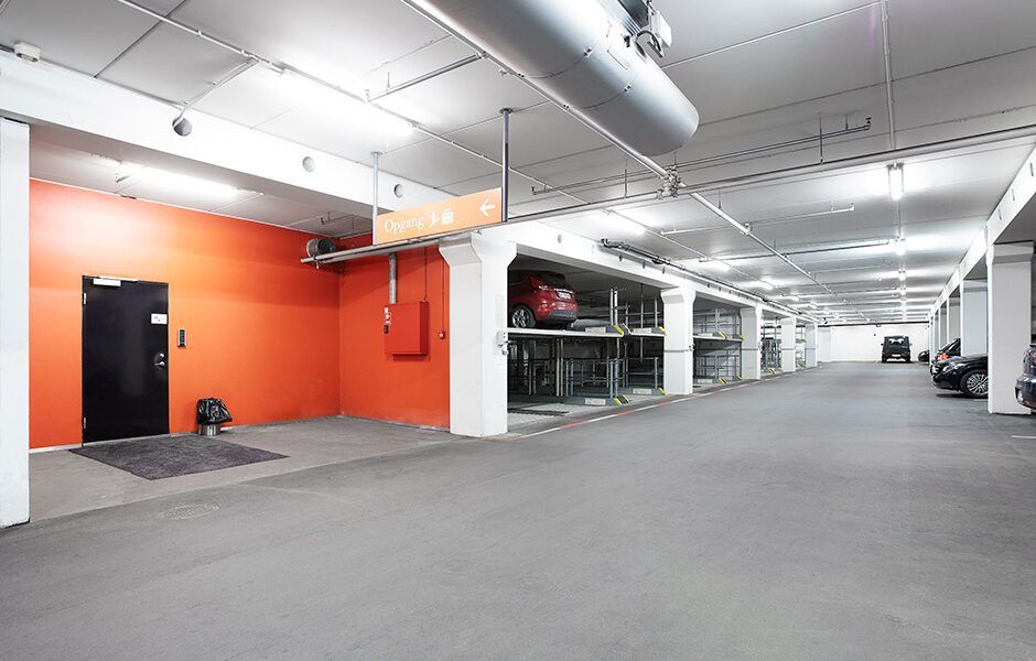 Et parkeringshus med en masse biler parkeret i det.