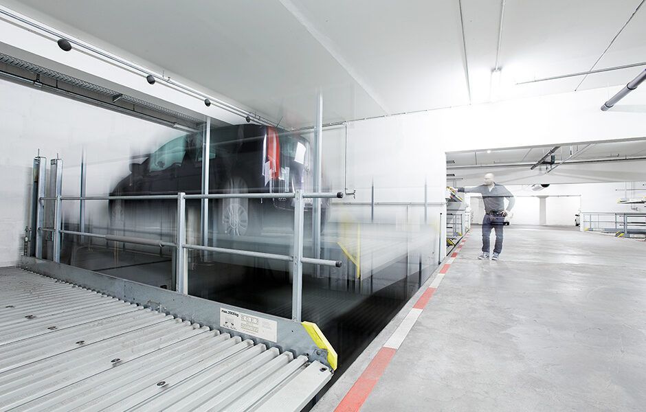 En bil bliver løftet ind i en parkeringskælder.