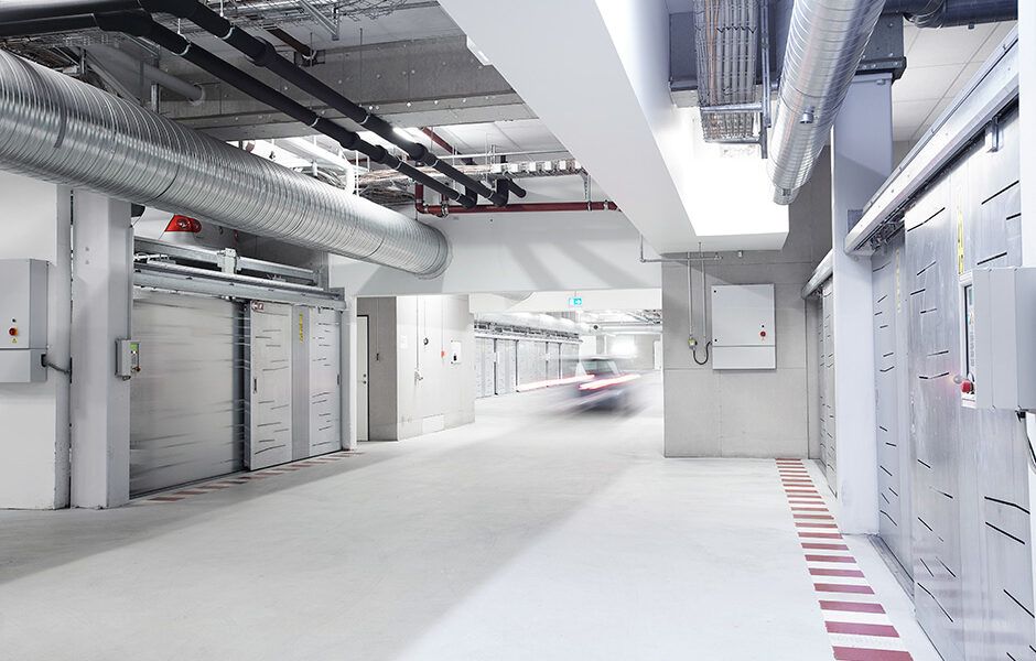 En bil kører ned ad en gang i en parkeringskælder.