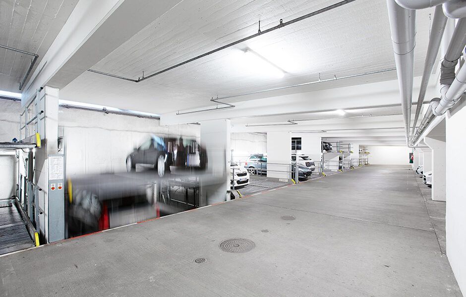 Et parkeringshus med en masse biler parkeret i det.