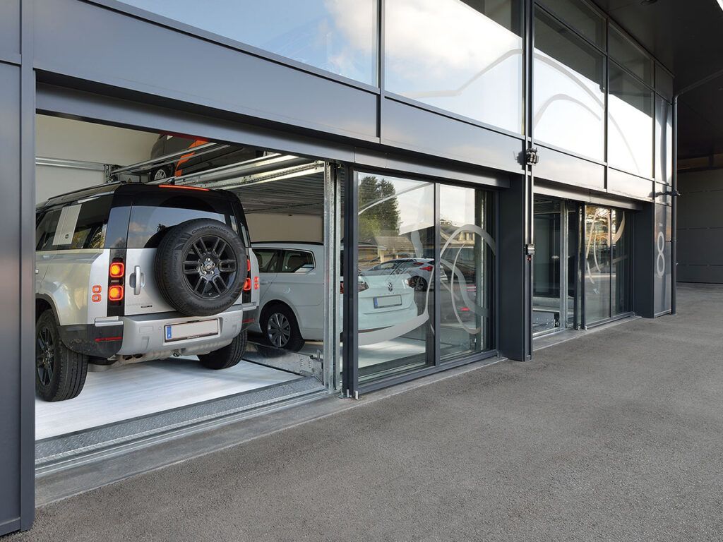 En bil er parkeret i en garage med åbne døre.