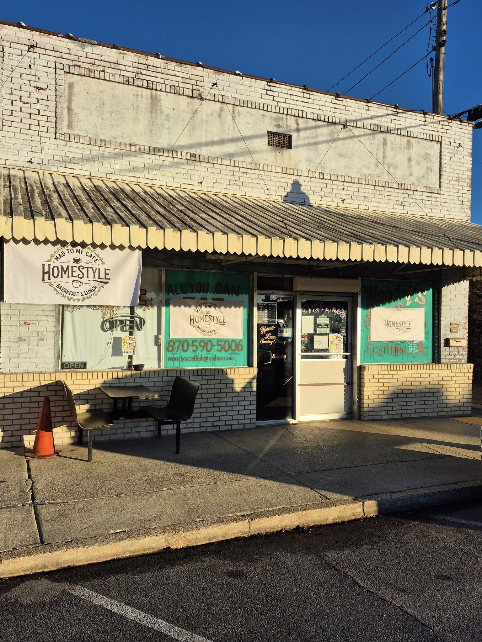 Storefront with white brick exterior, teal trim, and awning; 
