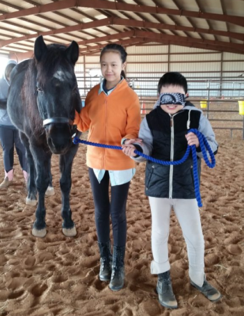 A boy and a girl are standing next to a horse - Anna, TX - Spirit Song Youth Equestrian Academy