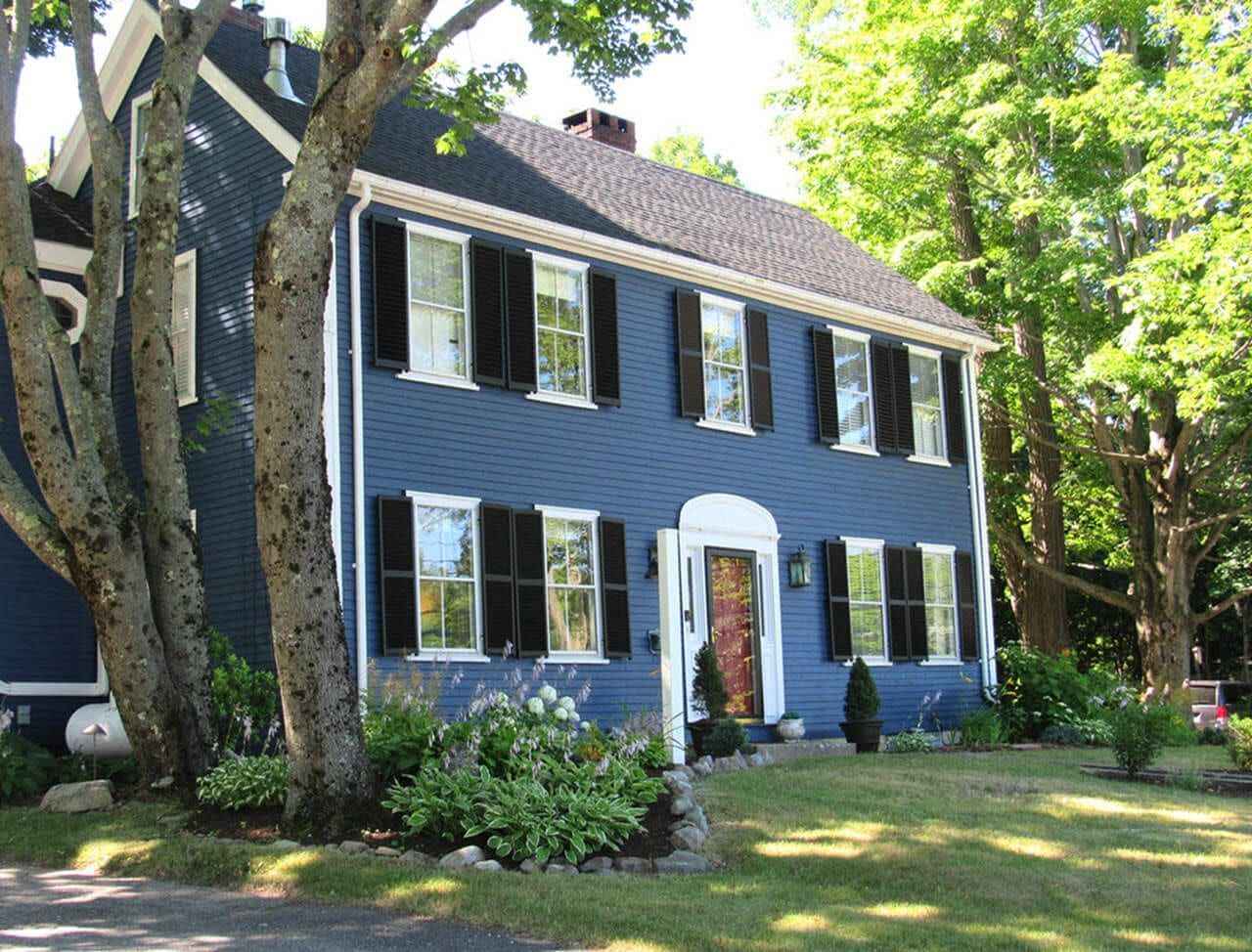 A blue house with white trim and black shutters