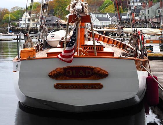 A boat named olard is docked in a harbor