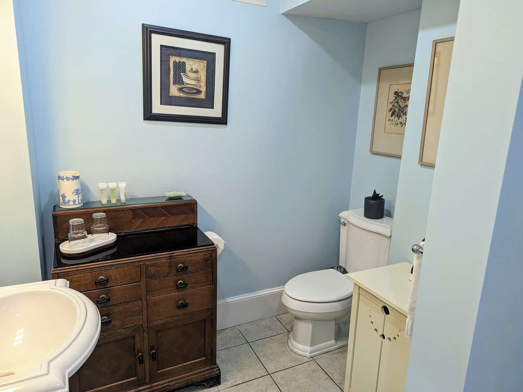 A bathroom with a sink , toilet and picture on the wall