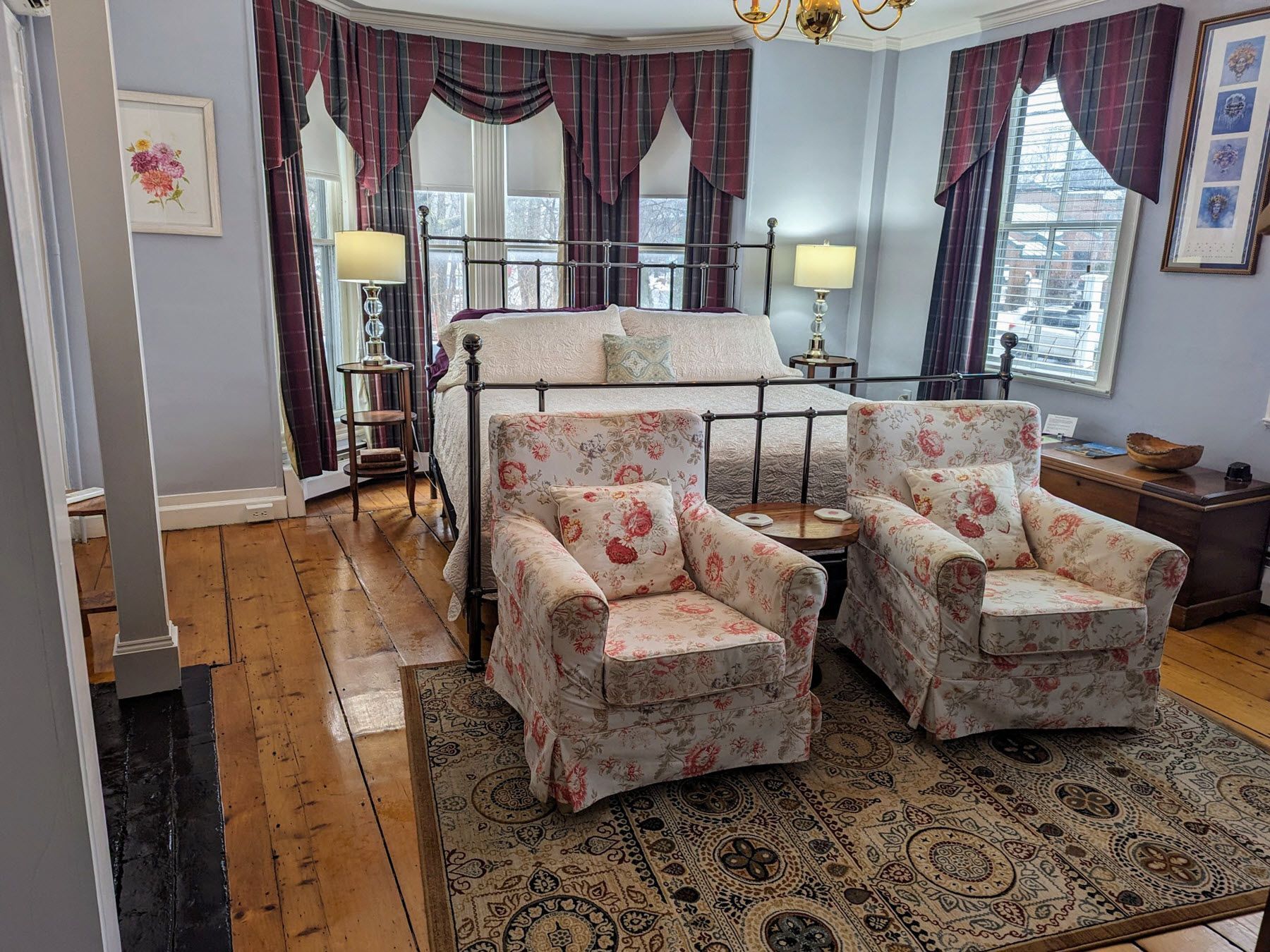 A bedroom with a bed , two chairs , and a rug.