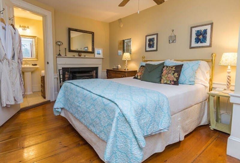 A bedroom with a king size bed and a fireplace.